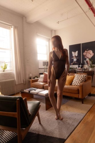 Josilee Adams, New Jersey escort, wearing a striped brown bodysuit