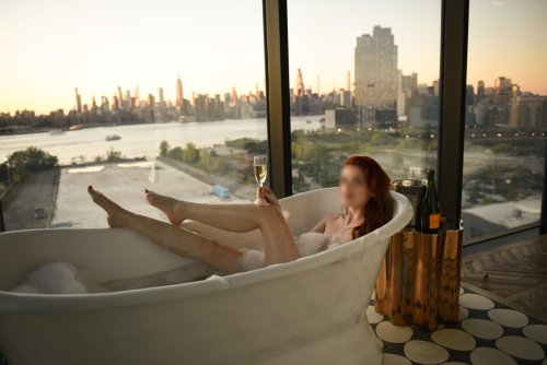 Josilee Adams, New Jersey escort, poses with her legs sticking out of a bubble bath