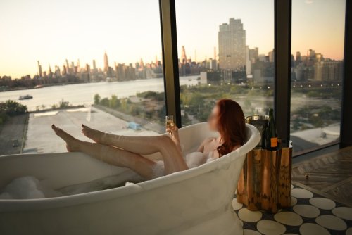 Josilee Adams, New Jersey escort, poses with her legs sticking out of a bubble bath